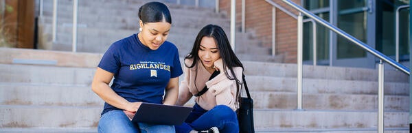 Students On Steps Looking at a Laptop