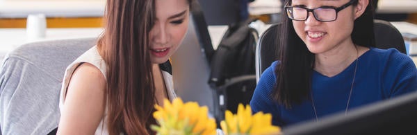 girls looking at laptop and smiling